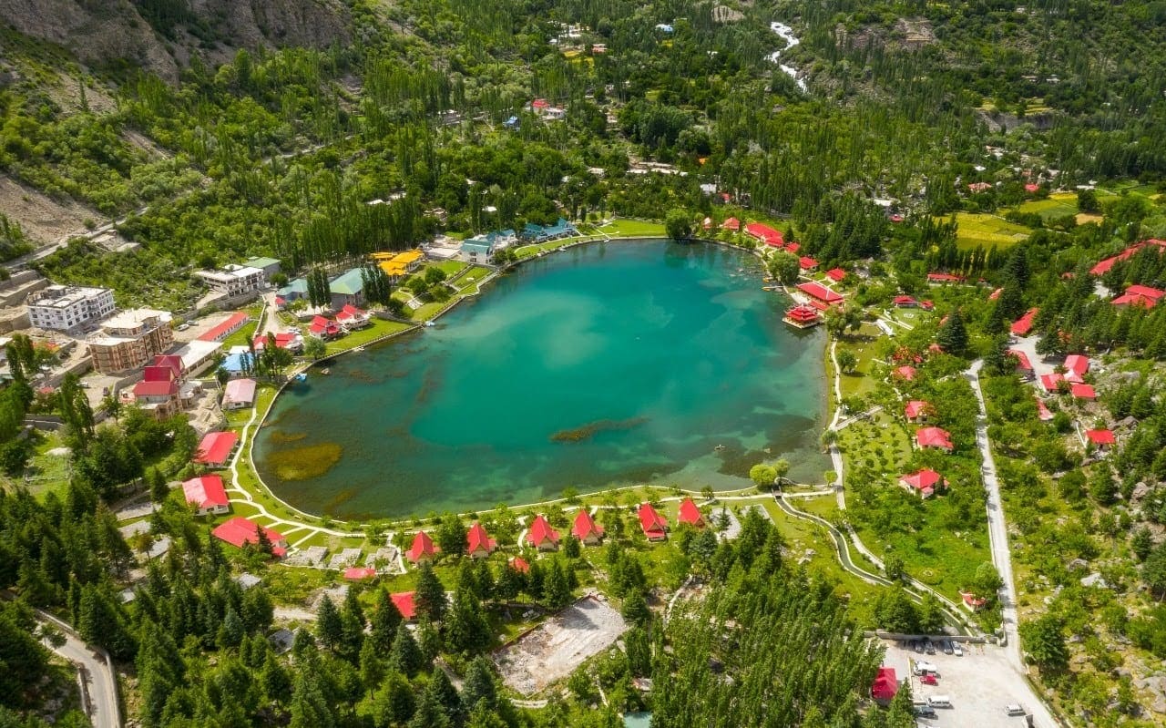 Aerial view of the Marco Polo resort in Skardu with a turquoise lake and landscaped grounds